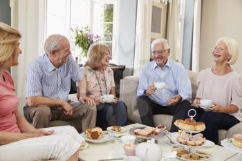 Group Of Senior Friends Enjoying Afternoon Tea At Home Together