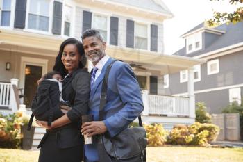 Portrait Of Business Couple With Baby Son Leaving House For Work