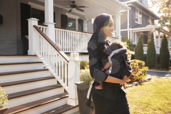 Businesswoman With Baby Son Leaving House For Work