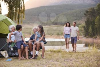 Multi Generation Family On Camping Trip By Lake Together