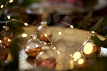 Close up of Christmas baubles on a gold table with warm glow, selective focus