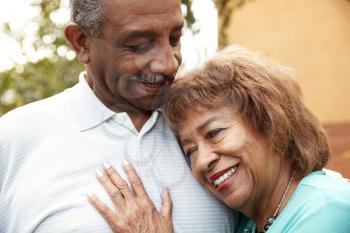 Senior black husband and wife embracing outdoors, close up