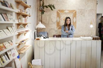 Portrait Of Female Owner Of Independent Clothing And Gift Store Behind Sales Desk