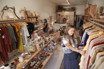 Customers Browsing In Independent Clothing And Gift Store