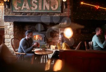 Couple Meeting For Lunchtime Drinks In Traditional English Pub Making A Toast