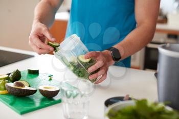 Close Up Of Man Preparing Ingredients For Healthy Juice Drink After Exercise
