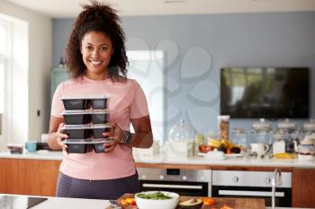 Portrait Of Woman Preparing Batch Of Healthy Meals At Home In Kitchen