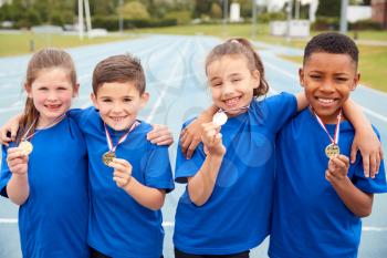 Portrait Of Children Showing Off Winners Medals On Sports Day