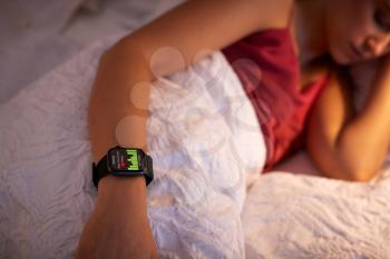 Woman Sleeping In Bed With Focus On Smart Watch She Is Wearing