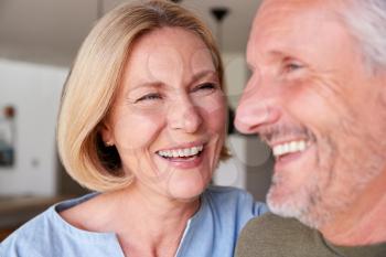 Close Up Of Smiling Senior Couple Standing At Home In Kitchen Together