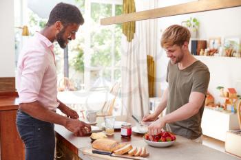 Male Gay Couple At Home In Kitchen Making Breakfast Together