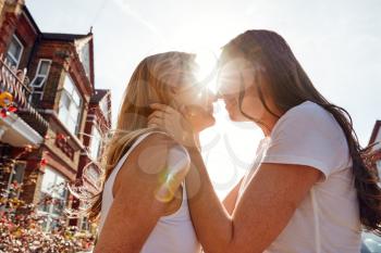Female Gay Couple Outside House About To Kiss Against Flaring Sun