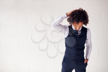 Confident Young Businessman Wearing Suit Standing Against White Studio Wall