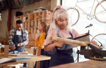 Multi-Cultural Team In Workshop Assembling Hand Built Sustainable Bamboo Bicycle Frame