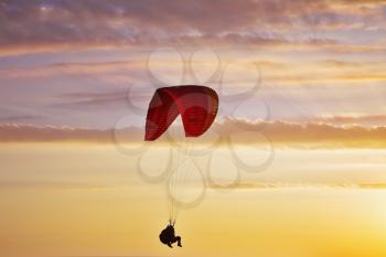 Flight on an operated parachute in twilight on a sunset