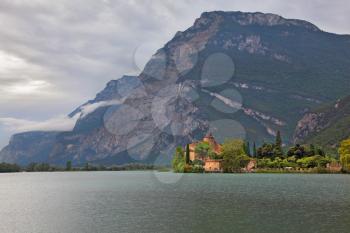 Toblino lake in the mountains of northern Italy and a medieval castle
