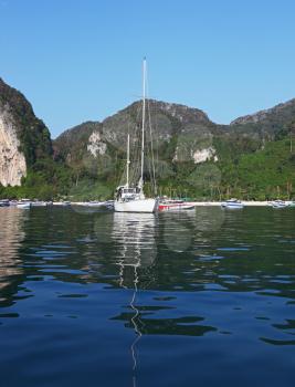 Romantic white yacht in the azure bay, surrounded by wooded hills
