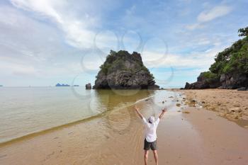 Magnificent beach on the bank of the Thai gulf. The enthusiastic tourist welcomes sunrise.
