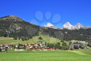 Gorgeous weather in the resort town of Leysin in the Swiss Alps. Picturesque gentle alpine meadows and rural houses chalets