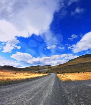 Picture taken with a fisheye lens.  The dirt road in the Chile National Park Torres del Paine. Magic clouds incredible shapes formed by glaciers shining in the sun. Patagonia. 