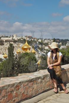 The magnificent golden domes of the Orthodox Church in Jerusalem. Admiring a woman looks at the panorama of Jerusalem in the hills