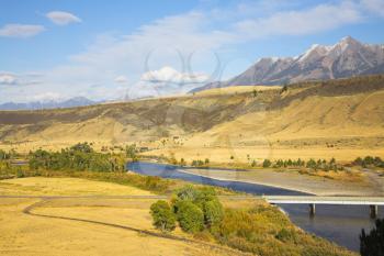 The river Missouri is beautifully bent between brightly yellow meadows, and on a background are visible  mountains    