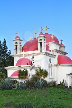  Bright pink dome, whitewashed walls of the holy temple on the shore of the Sea of Galilee. Greek  Monastery of the Twelve Apostles.