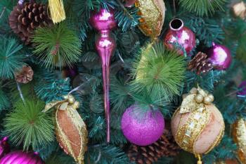 Pink and yellow spheres, decorative snowflakes, glass peaks and figures of fantastic heroes decorate a New Year treel. Happy Christmas!
