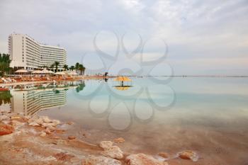 Winter in the Dead Sea. The comfortable high-rise hotel  is reflected in the sea smooth water