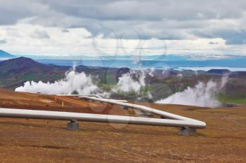  Pipeline to transport hot water. Krafla Lake neighborhood. Summer Iceland. Steam rises above the hot ground