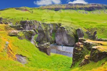  Enthusiastic woman - tourist on a rock canyon  Fjadrargljufur. Fantastic country Iceland