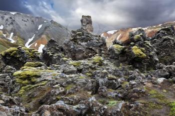 National Park Landmannalaugar in Iceland. Pieces of gray and black lava bizarre shapes, sometimes covered with green moss