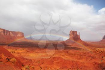 The majestic Monument Valley. A giant rainbow over the cliffs of sandstone Mittens