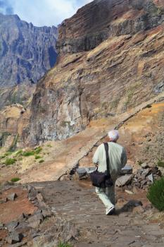 The top of the island of Madeira - Pico Ruyvu. Tourist-photographer with a great photo bag is on a narrow path in the mountains