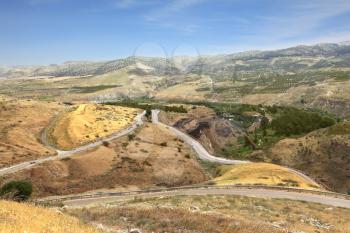 Yarmouk River valley on the border between Jordan and Israel. Spring sun dry grass along the roadside. Resort area Hamat Gader.