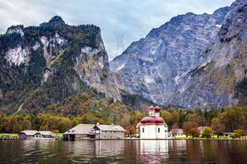 Dreamlike beauty of on the lake Konigssee. Red domes and white walls of the Church of St. Bartholomew  reflected in the water