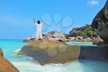  Middle-aged woman dressed in white doing yoga. Asana Blessing of the Sun. Thailand. Gorgeous beach on the Similan Islands.