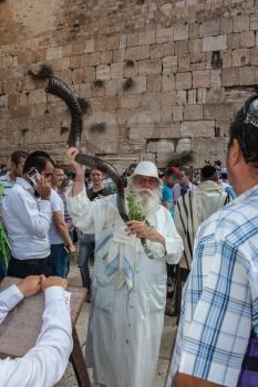 JERUSALEM, ISRAEL - OCTOBER 12, 2014: Morning autumn Sukkot. The area in front of Western Wall of  Temple filled with people. Elderly religious Jew with a Shofar