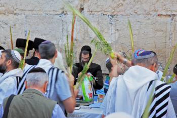 JERUSALEM, ISRAEL - SEPTEMBER 20, 2013: Morning Sukkot. Many religious Jews in traditional robes tallit gathered for prayer. The Western Wall of the Temple in Jerusalem