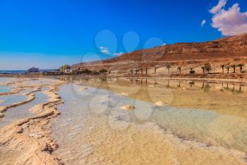 The Dead Sea at coast of Israel. The evaporated salt forms freakish patterns on a water surface