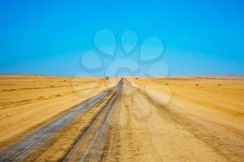  Dirt road in the endless Namib Desert. Concept of exotic and extreme tourism