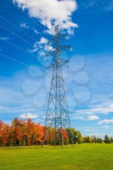 Power line support. Shining sunny day in French Canada.  Red and green autumn foliage