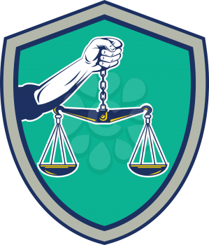 Illustration of a hand holding weighing scale scales of justice viewed from front set inside shield crest on isolated background done in retro style.