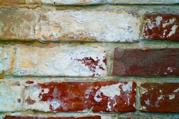 old red brick wall with some traces of former paint jobs