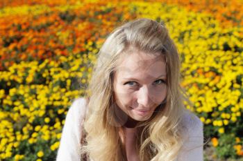 Outdoor portrait of young woman against flowerbed