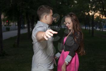 Happy young adult couple dancing outdoors at night, close-up