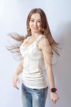 Young female dancing, fluttering on the wind hair, over white background