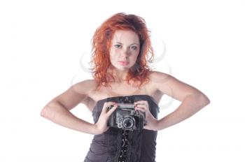 Photo of a beautiful female with red hair holding an old film camera.