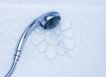 Shower Head with Running Water, Blue background. Shower and flying water drops.
