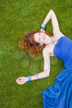 20s redhead women lay in the fresh grass and having summertime fun and enjoyment